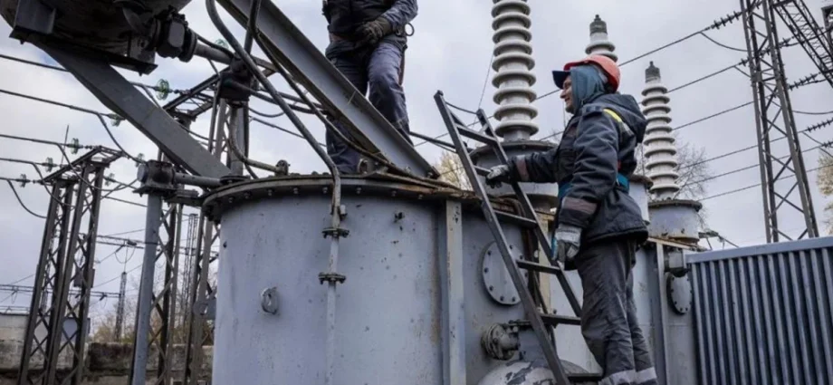Електромонтер працює на електричній підстанції серед трансформаторів