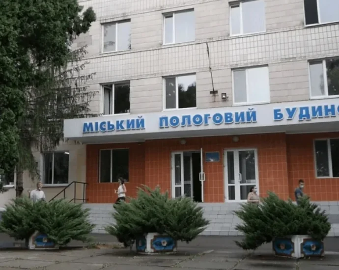 Фасад міського пологового будинку з людьми біля входу