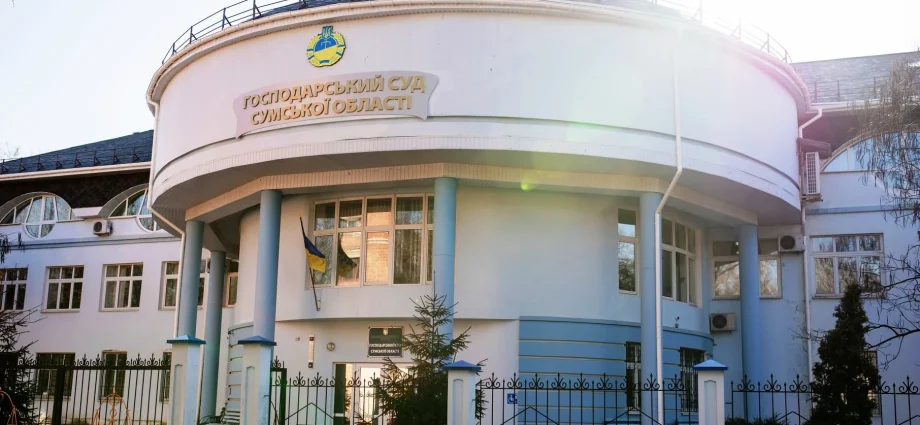 Біла кругла будівля Господарського суду Сумської області з прапором України