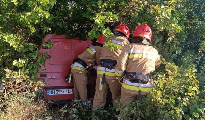 Рятувальники біля червоного пікапа Таврія, що врізався в кущі