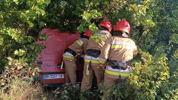 Рятувальники біля червоного пікапа Таврія, що врізався в кущі