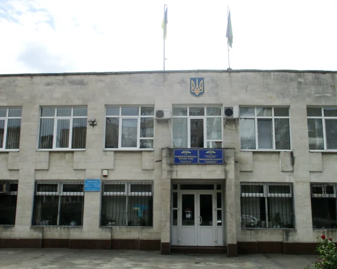 Фасад Південноукраїнської міської ради з гербом і прапорами України