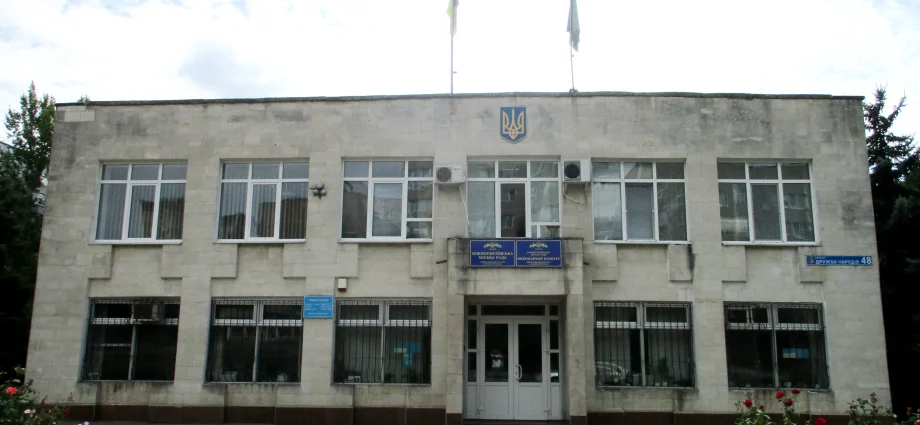Фасад Південноукраїнської міської ради з гербом і прапорами України