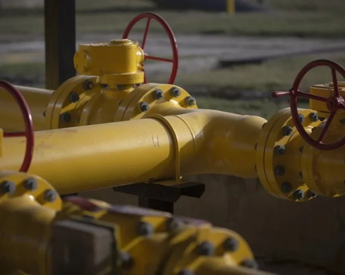 Жовті газові труби з червоними вентилями на відкритій ділянці мережі